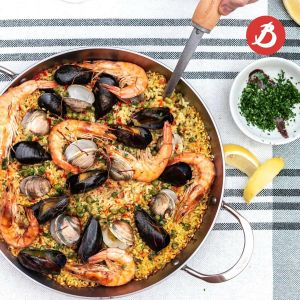 cooking paella in a premium french carbon steel paella pan